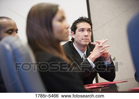 Contemplative business executive with clasped hands listening to his colleagues View Large Photo Image Stock Photograph - Contemplative business executive with clasped hands listening to his colleagues. Fotosearch