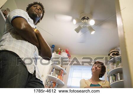 Contemplative inter-racial couple standing in a kitchen View Large Photo Image Stock Image - Contemplative inter-racial couple standing in a kitchen. Fotosearch