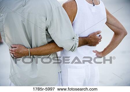 Cropped rear view of couple standing side by side View Large Photo Image Stock Photo - Cropped rear view of couple standing side by side. Fotosearch