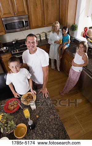 Elevated view of a family with young children and an adopted child having breakfast in their kitchen View Large Photo Image Picture - Elevated view of a family with young children and an adopted child having breakfast in their kitchen. Fotosearch
