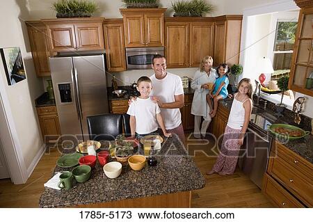 Stock Image - Elevated view of a family with young children and an adopted child having breakfast in their kitchen. Fotosearch