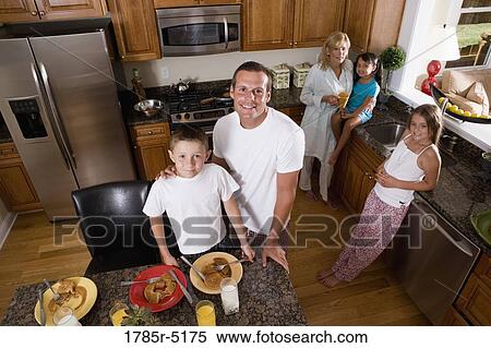 Elevated view of a family with young children and an adopted child having breakfast in their kitchen View Large Photo Image Stock Photography - Elevated view of a family with young children and an adopted child having breakfast in their kitchen. Fotosearch