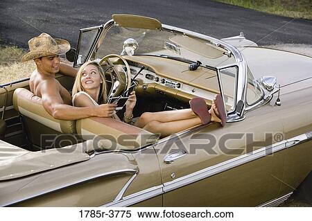 Elevated view of a young couple sitting in antique convertible car View Large Photo Image Stock Photography - Elevated view of a young couple sitting in antique convertible car. Fotosearch