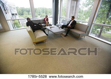 Stock Photo - Elevated view of business people sitting and waiting in an office lounge area. Fotosearch
