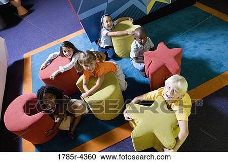 Elevated view of children hugging colorful seats of various shapes View Large Photo Image Stock Image - Elevated view of children hugging colorful seats of various shapes. Fotosearch