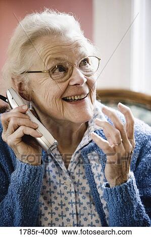 Excited and happy senior woman talking on cordless phone View Large Photo Image Stock Photo - Excited and happy senior woman talking on cordless phone. Fotosearch