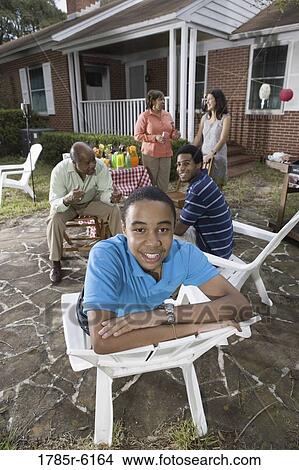 Family and friends enjoying backyard barbeque View Large Photo Image Picture - Family and friends enjoying backyard barbeque. Fotosearch