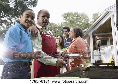 Stock Image - Family and friends enjoying backyard cookout. Fotosearch