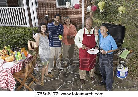 Family and friends enjoying backyard cookout View Large Photo Image Stock Photo - Family and friends enjoying backyard cookout. Fotosearch
