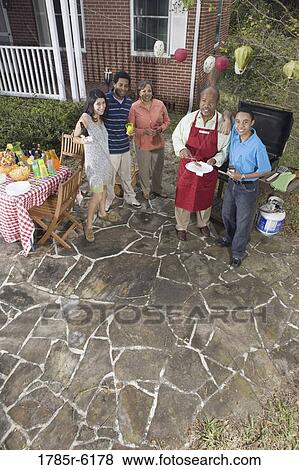 Stock Photo - Family and friends enjoying backyard cookout. Fotosearch
