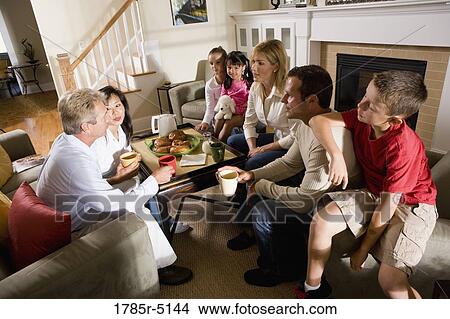 Family and friends having breakfast together in living room View Large Photo Image Picture - Family and friends having breakfast together in living room. Fotosearch
