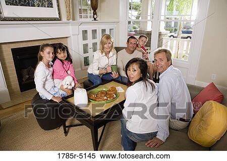 Family and friends having breakfast together in living room View Large Photo Image Stock Photography - Family and friends having breakfast together in living room. Fotosearch