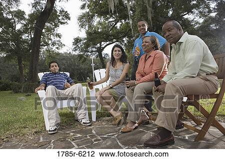 Family and friends relaxing in backyard View Large Photo Image Stock Image - Family and friends relaxing in backyard. Fotosearch