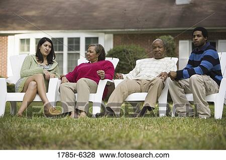 Family and friends relaxing on lawn chairs in backyard View Large Photo Image Stock Photo - Family and friends relaxing on lawn chairs in backyard. Fotosearch