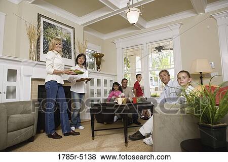 Family and friends together in living room View Large Photo Image Stock Photo - Family and friends together in living room. Fotosearch