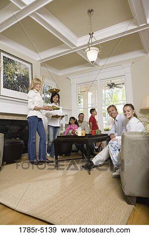 Family and friends together in living room View Large Photo Image Stock Photo - Family and friends together in living room. Fotosearch