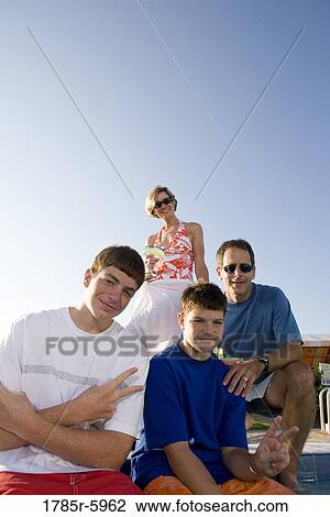 Stock Image - Family at the edge of a swimming pool. Fotosearch