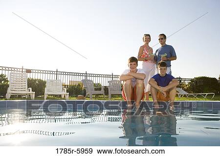 Family at the edge of a swimming pool View Large Photo Image Stock Photo - Family at the edge of a swimming pool. Fotosearch