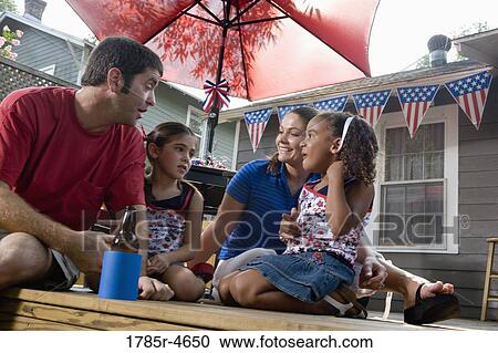 Family on backyard patio with 4th of July decorations in background View Large Photo Image Stock Image - Family on backyard patio with 4th of July decorations in background. Fotosearch