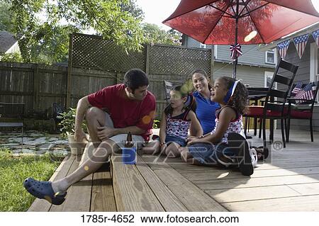 Family on backyard patio with 4th of July decorations in background View Large Photo Image Stock Image - Family on backyard patio with 4th of July decorations in background. Fotosearch