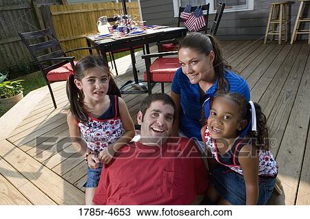 Family on backyard patio with 4th of July decorations in background View Large Photo Image Stock Image - Family on backyard patio with 4th of July decorations in background. Fotosearch