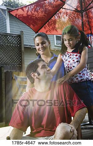 Family on backyard patio with 4th of July decorations in background View Large Photo Image Stock Photo - Family on backyard patio with 4th of July decorations in background. Fotosearch