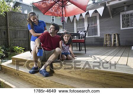 Family on backyard patio with 4th of July decorations in background View Large Photo Image Stock Photo - Family on backyard patio with 4th of July decorations in background. Fotosearch