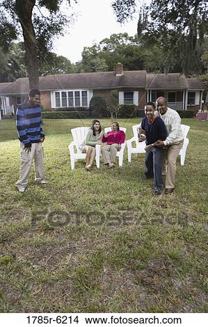 Family playing football in backyard View Large Photo Image Picture - Family playing football in backyard. Fotosearch