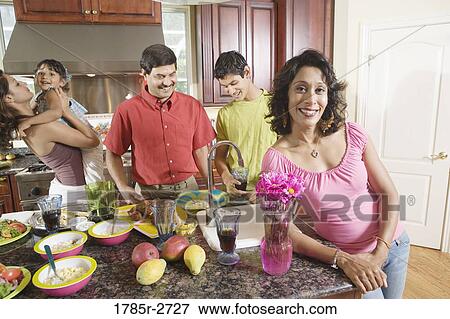 Family preparing food together in the kitchen View Large Photo Image Stock Photo - Family preparing food together in the kitchen. Fotosearch