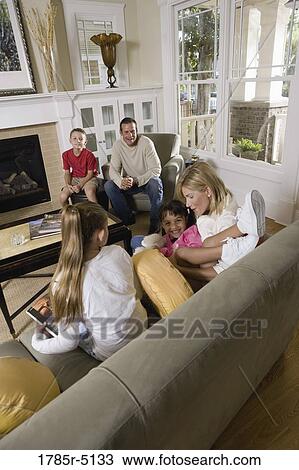 Family sitting together in the living room View Large Photo Image Stock Image - Family sitting together in the living room. Fotosearch