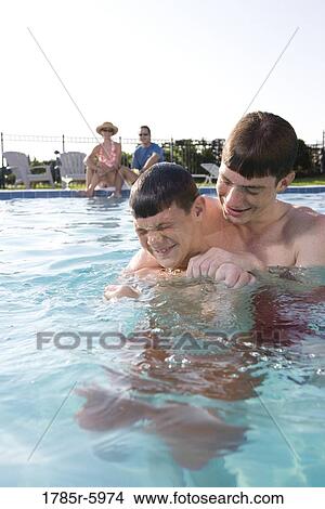 Picture - Family vacation at a swimming pool. Fotosearch