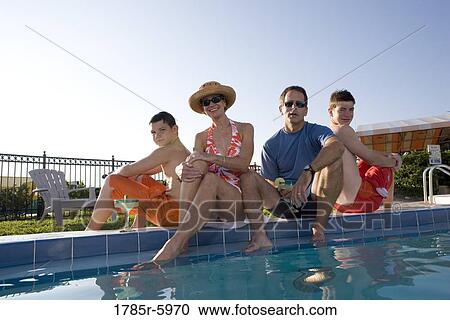 Stock Image - Family vacation at a swimming pool. Fotosearch