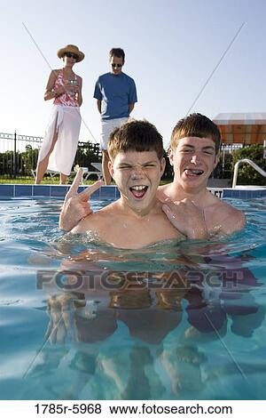 Stock Photo - Family vacation at a swimming pool. Fotosearch