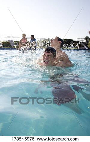 Stock Photograph - Family vacation at a swimming pool. Fotosearch