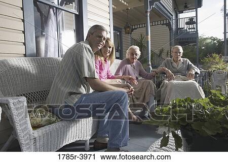 Family with elderly parents and adult children sitting together on front porch View Large Photo Image Stock Image - Family with elderly parents and adult children sitting together on front porch. Fotosearch