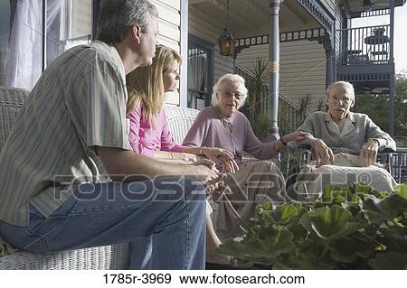 Family with elderly parents and adult children sitting together on front porch View Large Photo Image Stock Photo - Family with elderly parents and adult children sitting together on front porch. Fotosearch