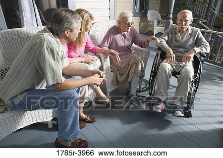 Family with elderly parents and adult children sitting together on front porch View Large Photo Image Stock Photograph - Family with elderly parents and adult children sitting together on front porch. Fotosearch