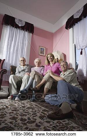 Family with senior parents and adult children sitting together in a living room View Large Photo Image Stock Image - Family with senior parents and adult children sitting together in a living room. Fotosearch