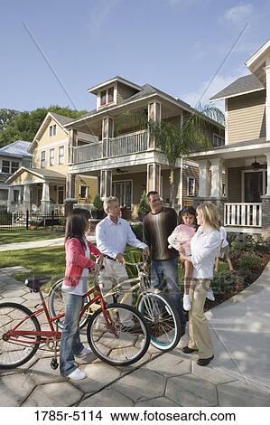 Family with young child conversing with neighbors in front of house View Large Photo Image Picture - Family with young child conversing with neighbors in front of house. Fotosearch
