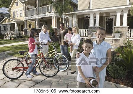 Stock Photograph - Family with young children conversing with neighbors in front of house. Fotosearch