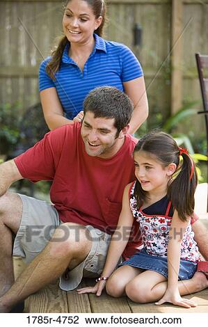 Family with young girl spending time on their backyard patio View Large Photo Image Stock Image - Family with young girl spending time on their backyard patio. Fotosearch