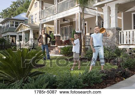 Stock Photo - Father and children playing catch in front yard. Fotosearch