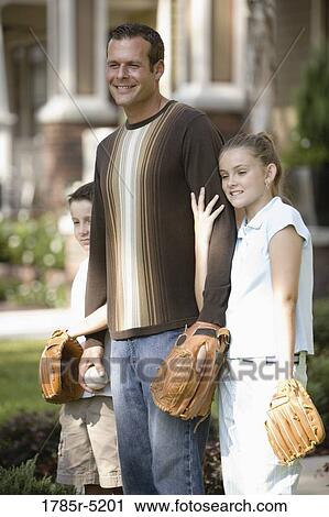 Father and his children standing in front of house with baseball and gloves View Large Photo Image Stock Image - Father and his children standing in front of house with baseball and gloves. Fotosearch