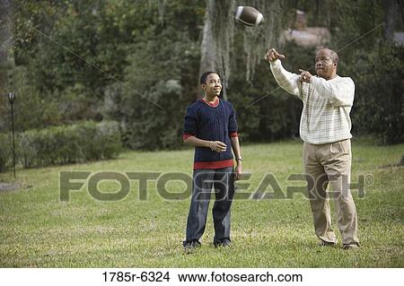 Father and son playing football in backyard View Large Photo Image Picture - Father and son playing football in backyard. Fotosearch