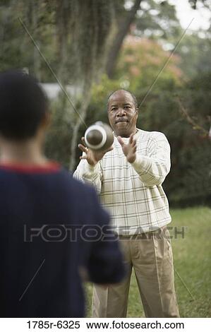 Father and son playing football in backyard View Large Photo Image Stock Photography - Father and son playing football in backyard. Fotosearch
