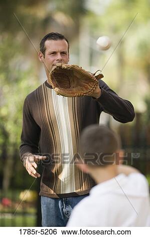 Stock Photograph - Father catching a baseball thrown by his son. Fotosearch