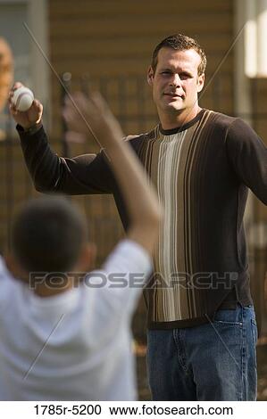 Stock Image - Father throwing a baseball to his son. Fotosearch