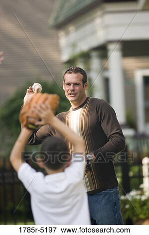 Stock Photo - Father throwing a baseball to his son. Fotosearch