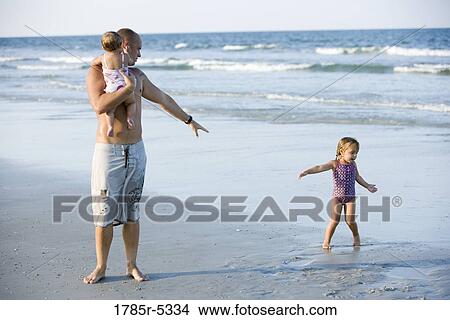 Father with young daughters at the beach View Large Photo Image Picture - Father with young daughters at the beach. Fotosearch
