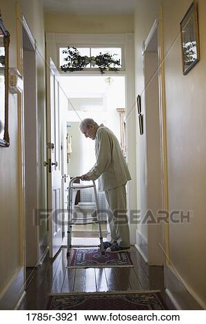 Feeble senior man slowly going down hallway with walker View Large Photo Image Stock Image - Feeble senior man slowly going down hallway with walker. Fotosearch